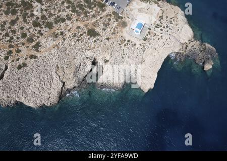 Drone aerial photograph of Cape Greco peninsula with Agioi Anargyroi christian chapel on the rocks. Turquoise ocean water, Ayia Napa Cyprus Stock Photo