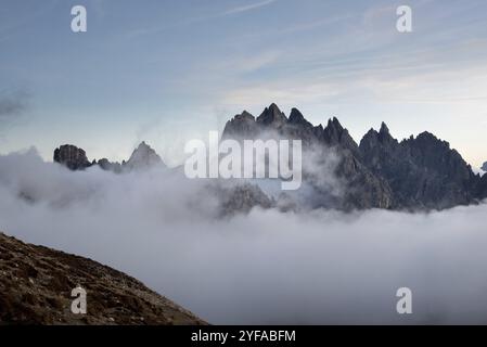 Dolomites mountain landscape rocky peaks above the clouds during sunset. Tre Cime di lavadero Italian alps, Italy, Europe Stock Photo