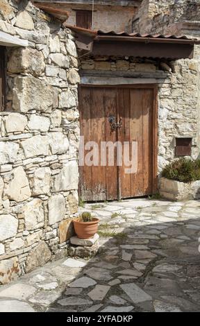 Stoned footpath crossing a traditional village. Stoned houses with wooden doors. Vintage architecture. Lofou village, Cyprus, Europe Stock Photo