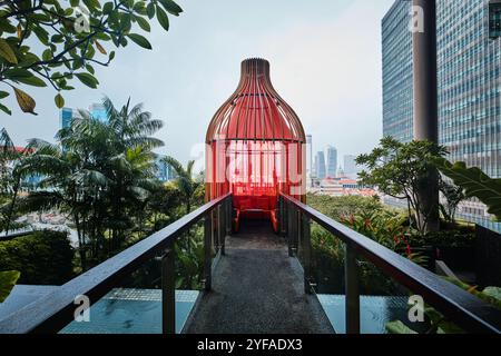 Singapore - August 16, 2024: Park Royal Collection Pickering Hotel infinity pool with tropical plants and colorful lodges Stock Photo