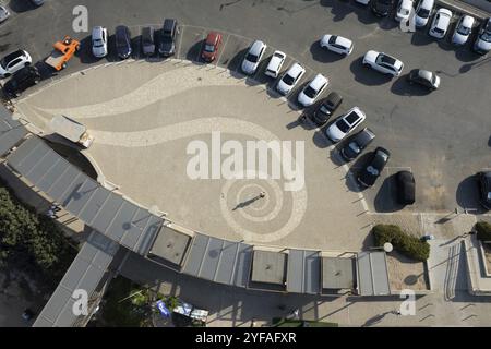 Drone aerial top view of car parking lot. Vehicles parked in a row on the street park outdoor. Fig tree bay Protaras Cyprus Stock Photo