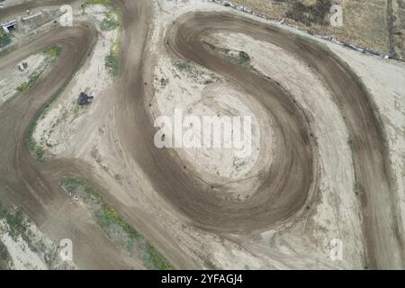 Drone aerial of a motocross race on a dirt curvy sport track. Aerial view of high-speed racing Stock Photo