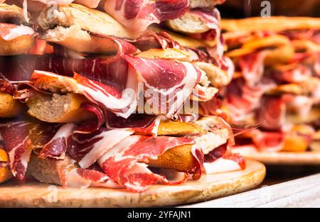 Traditional Spanish bocadillos with Iberico jamon laid out in a slide on a shop window Stock Photo