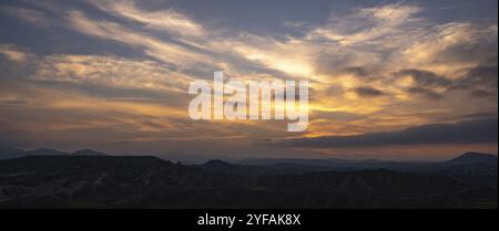 Sunset over the mountains with dramatic clouds. Panoramic mountain landscape at dusk Stock Photo