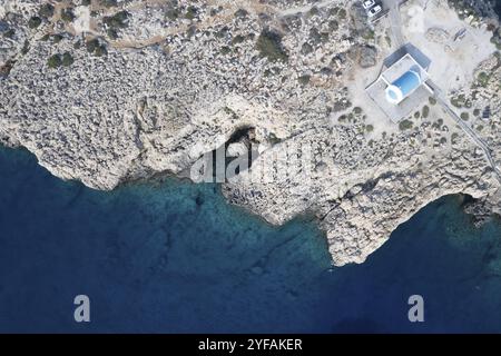 Drone aerial photograph of Cape Greco peninsula with Agioi Anargyroi christian church on the rocks. Turquoise ocean water Stock Photo