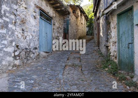 Stoned footpath crossing a traditional village. Stoned houses with wooden doors. Vintage architecture. Palaichori village, Cyprus, Europe Stock Photo