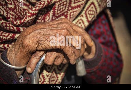 Close up details of the crossed wrinkle hands of an elder grandmother nepalese woman Stock Photo