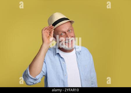 Portrait of happy senior man on yellow background Stock Photo