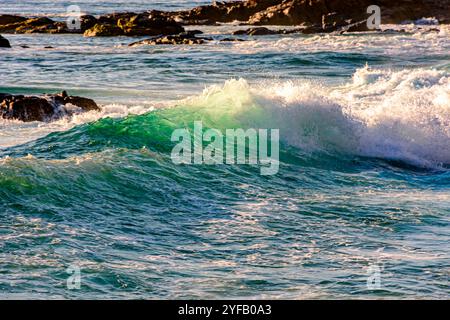 Small waves breaking on the beach in Salvador, Bahia during sunset Stock Photo