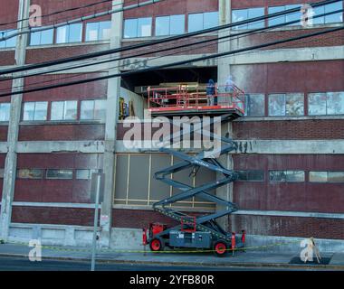 Men on a scissor lift working in a building Stock Photo
