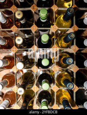 Rows of red and white wine in a modern wooden rack Stock Photo