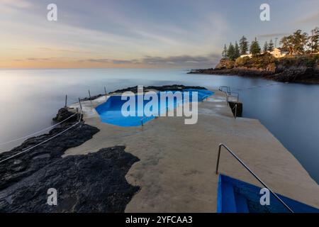 The charming coastal village of Caloura, nestled in the parish of Água de Pau, offers visitors a picturesque fishing port with a small beacon, a natur Stock Photo