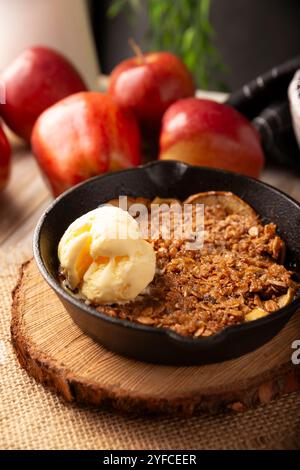 Apple oat crumble, walnuts, butter and brown sugar with vanilla ice cream topping, homemade recipe, traditional dessert perfect for the winter season Stock Photo