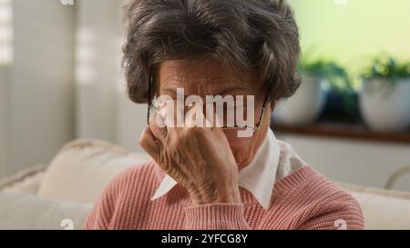 Old 60s Caucasian woman retired lady 70s senior aged female granny reading news open paper envelop read letter bad vision blurry eyesight correct Stock Photo