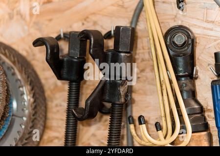 Detailed Close-Up of Various Mechanical Tools Hang on a Wooden Wall. Stock Photo