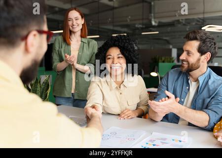 Happy diverse business team applauding congratulating black female leader after successful deal, signing contract at corporate meeting Stock Photo