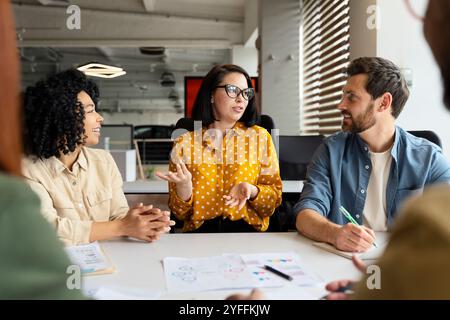 Team of diverse colleagues is having a productive meeting in a modern office, discussing new ideas and strategies for their business Stock Photo