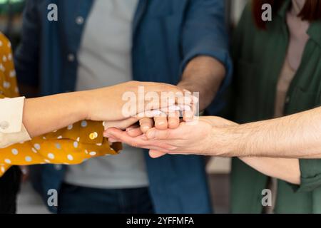Diverse group of business professionals is joining hands in a gesture of unity and teamwork Stock Photo