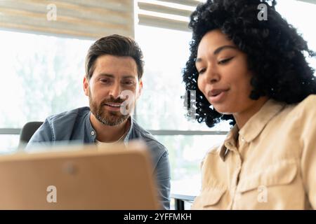 Two business people are having a meeting in the office and discussing over a digital tablet Stock Photo