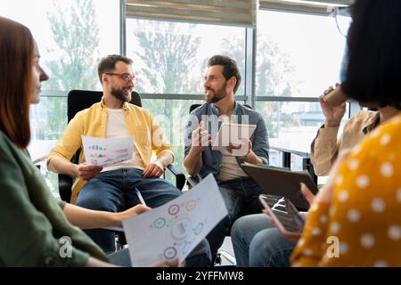Team of young professionals is having a productive meeting discussing new business ideas in a modern office Stock Photo