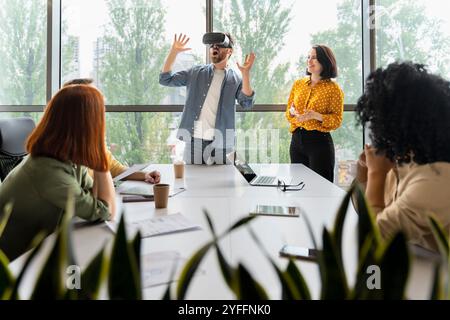 Businessman is using virtual reality glasses during a presentation to his colleagues in a modern office meeting room Stock Photo