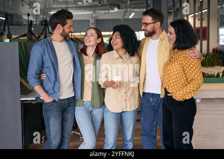 Five colleagues laughing and having fun together during a break in the office, they are happy and united Stock Photo