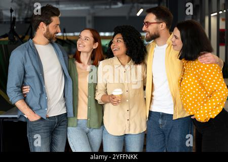 Five colleagues are laughing and chatting together during a break in the office Stock Photo