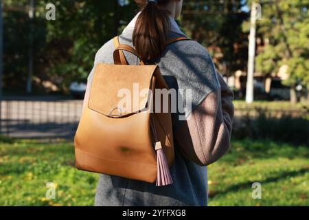 Woman with pink leather keychain on her backpack outdoors, closeup Stock Photo