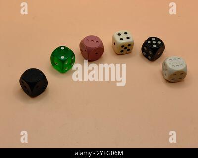 Colorful Dice Cubes on Brown Paper Surface – Numbers 1 to 6 Displayed. Fun time, education, concept. Stock Photo