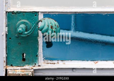 Vintage green forged handle of a metal door, close up photo Stock Photo