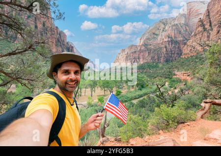 Handsome young tourist enjoying summer holiday in usa,  - Traveling life style concept with smiling man taking selfie on zion natural park - Tourism v Stock Photo