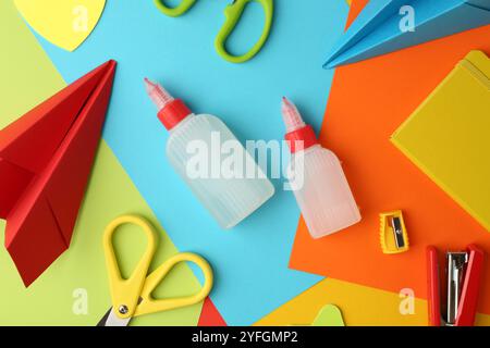 Flat lay composition with glue, scissors and other stationery on color background Stock Photo