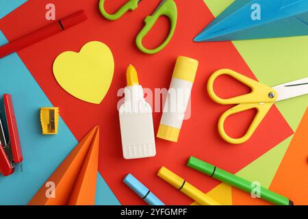 Flat lay composition with glue, scissors and other stationery on color background Stock Photo