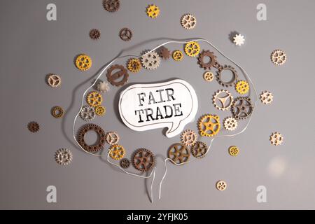 There is a word cube arranged in the shape of FAIR TRADE on a burlap bag with a ball of the earth. Stock Photo