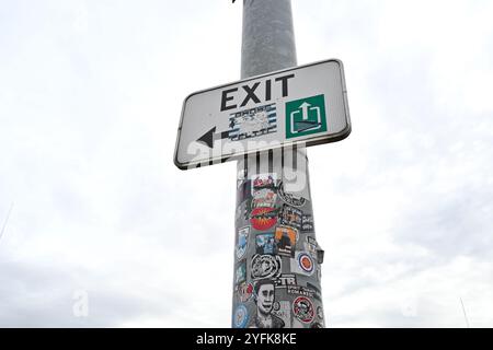 Exit sign covered in stickers – Charleroi, Belgium – 20 October 2024 Stock Photo