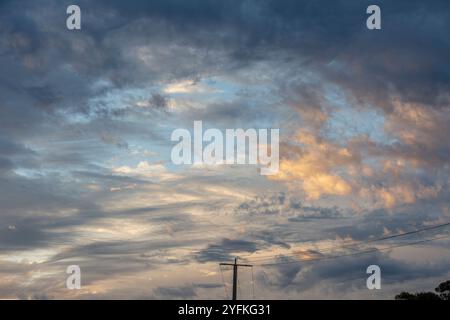 Dramatic, sunset skies with layers of cloud swirling and blue and pink highlights across clouds. Stock Photo