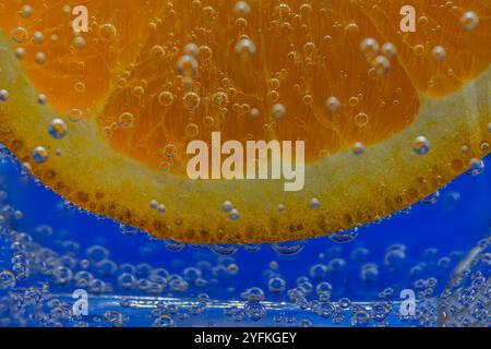 Close-up of an orange slice submerged in sparkling water with bubbles Stock Photo