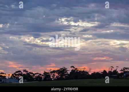 Dramatic, sunset skies with layers of cloud swirling and blue and pink highlights across clouds. Stock Photo