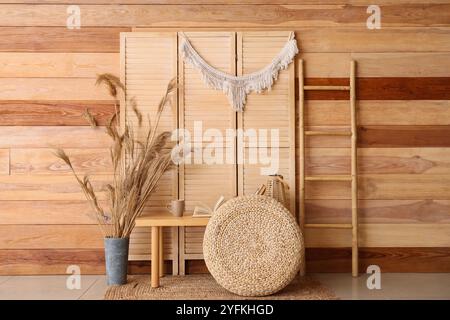 Interior of room with books on bench, pouf and folding screen Stock Photo