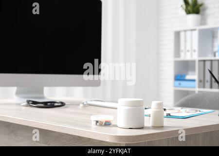 Pill bottles on doctor's desk in medical office, closeup Stock Photo