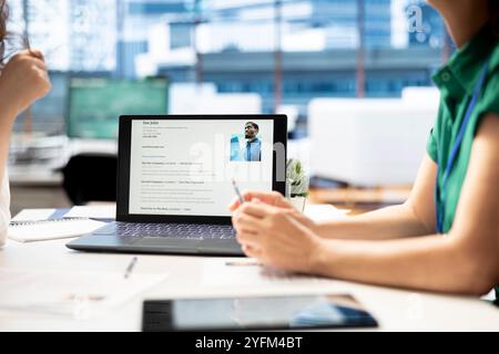 Notebook on office desk used by HR expert vetting applicants to ensure skills match role needs. Close up shot of laptop used by headhunter assessing candidate work experience Stock Photo