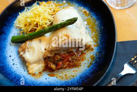 Cod fillet in aioli with ratatouille and fried potato straw Stock Photo