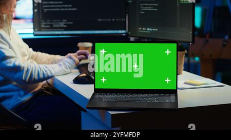 Programmer designing and developing software applications using isolated screen laptop. IT professional implementing and maintaining company systems using mockup notebook, camera A Stock Photo
