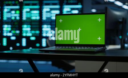 Focus on green screen laptop used by engineers in high tech data center to monitor security threats. Close up of mockup notebook used by workers ensuring compliance with regulations, camera A Stock Photo