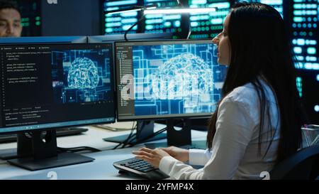 Technicians coworkers using AI tech on computer to do checkup in server room. Teamworking colleagues in data center using artificial intelligence technology to process datasets for training, camera A Stock Photo