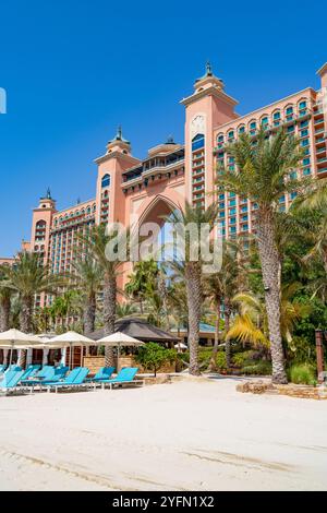 Exterior of 5 star luxury hotel, Atlantis the Palm hotel in Dubai with tropical palm trees and sunloungers on the beach, UAE,2024 Stock Photo