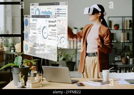 Young Woman Using VR Headset At Work Stock Photo