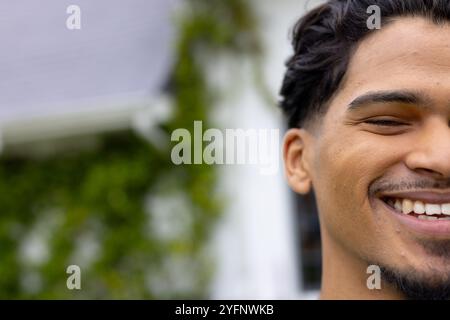 At holiday gathering, man smiling with multiracial friends outdoors, having fun together, copy space Stock Photo