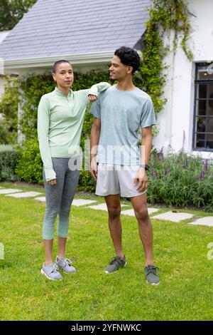 Young multiracial friends enjoying outdoor time together in casual athletic wear, smiling warmly Stock Photo