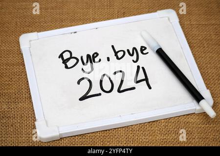 handwritten text Bye-bye 2024 on a whiteboard with pen Stock Photo
